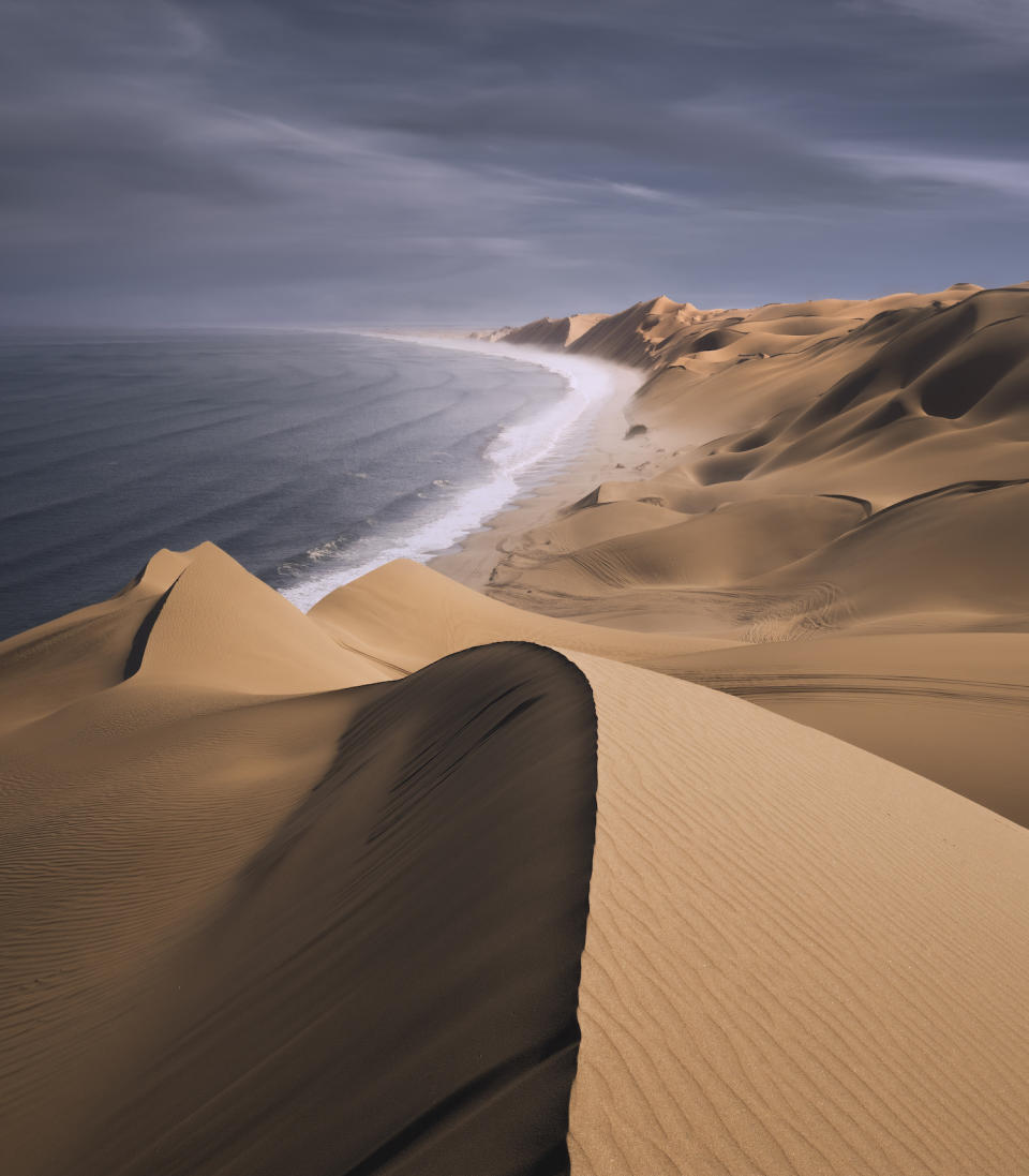 Large side dunes jut directly into the sea when the waves crash