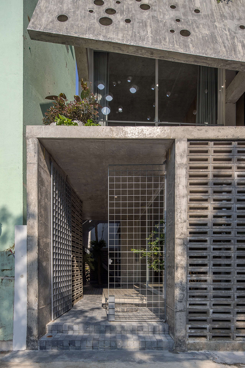 An irregular two-layer concrete facade envelops the Kho Ren House by M+TRO.studio in Vietnam