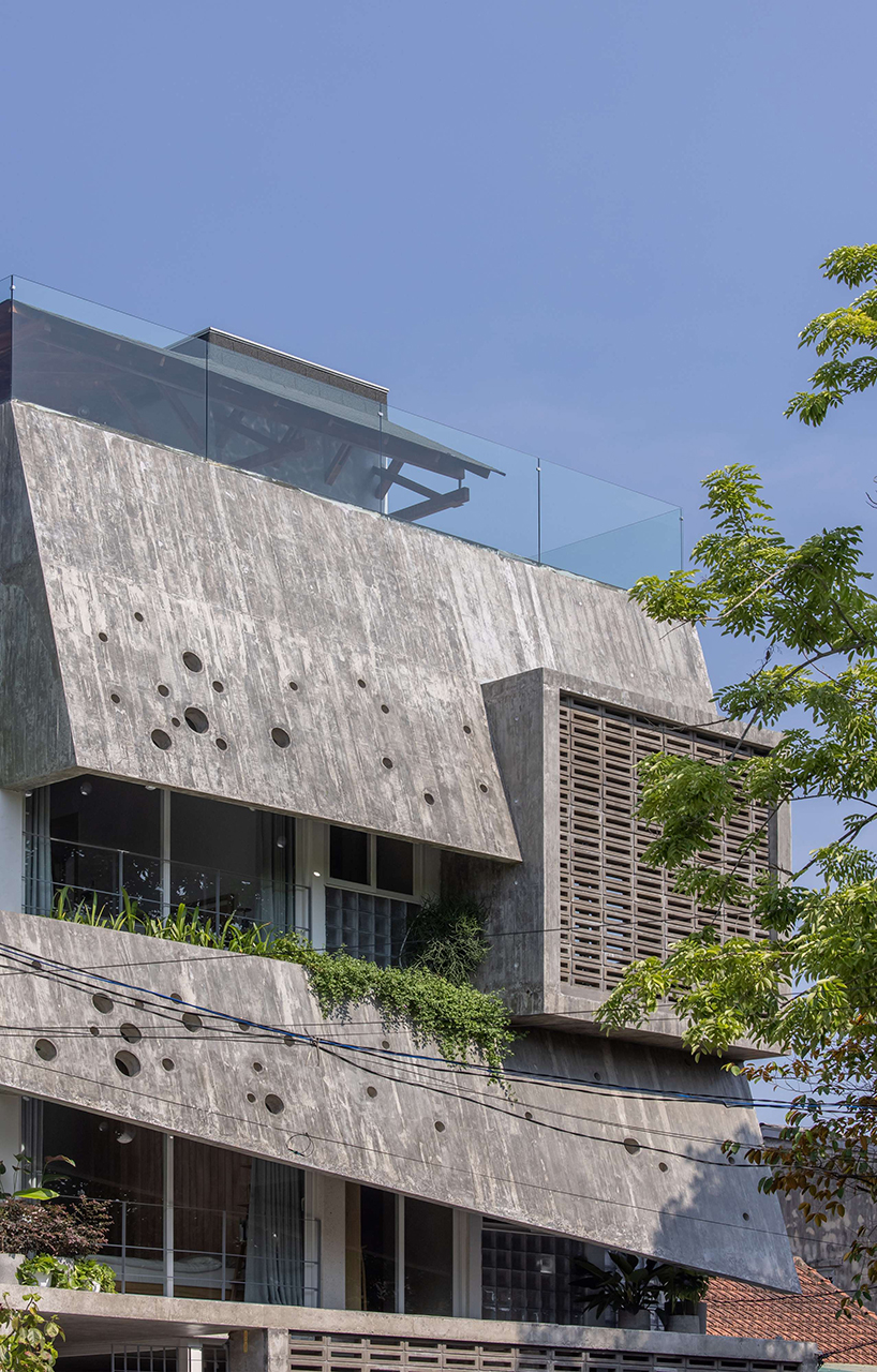 An irregular two-layer concrete facade envelops the Kho Ren House by M+TRO.studio in Vietnam