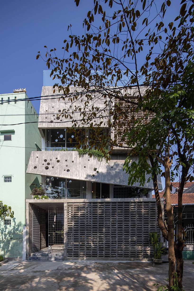 An irregular two-layer concrete facade envelops the Kho Ren House by M+TRO.studio in Vietnam