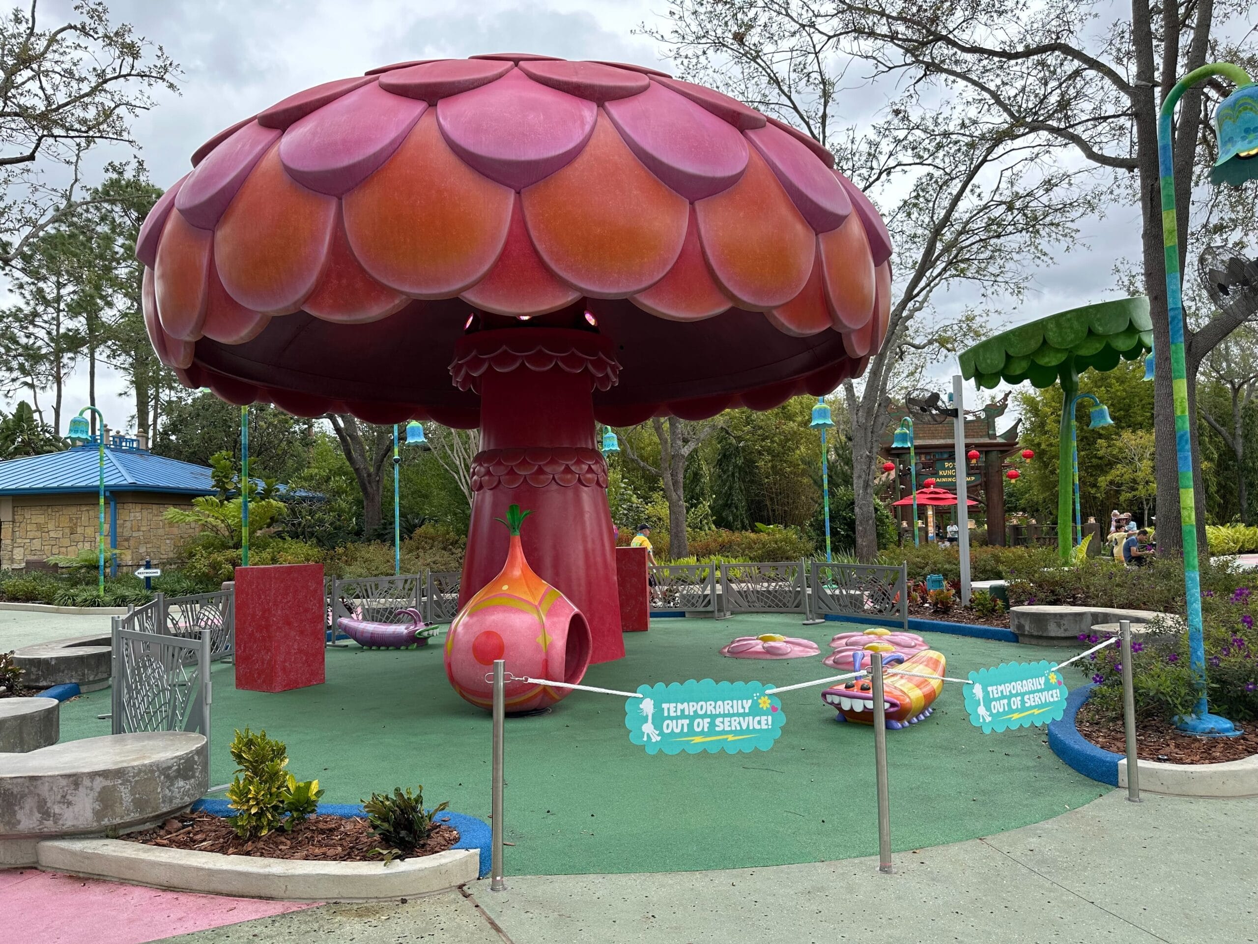 A mushroom-themed ride is temporarily out of service, with signs and barriers around it in place.