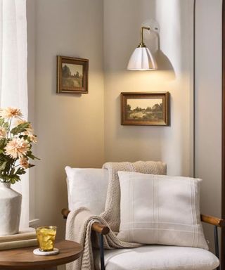 Living room corner with cream-colored armchair with ceiling lighting and vase with flowers