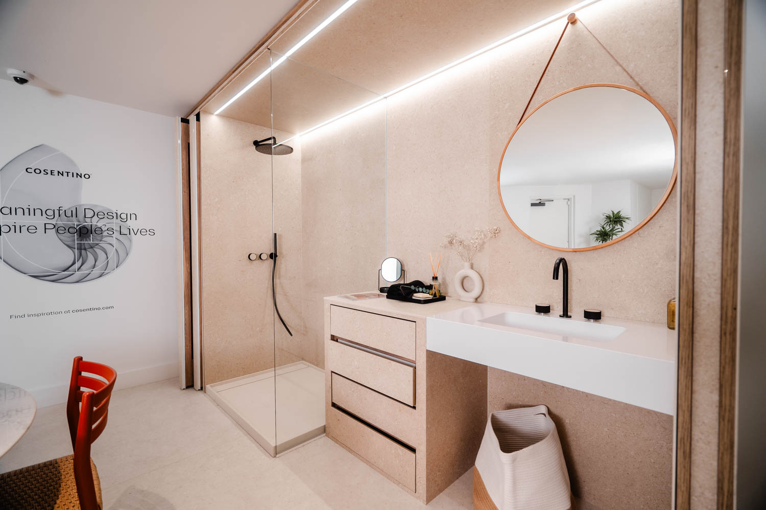 Fully equipped bathroom with pink walls, shower and desk