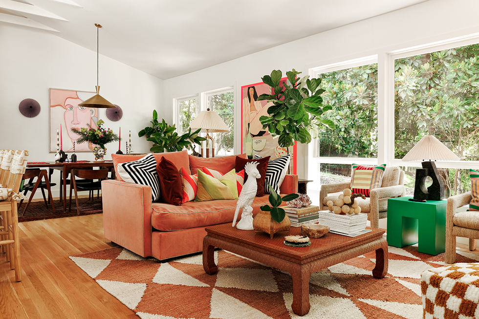 Living room with a coral sofa, decorative pillows and artwork