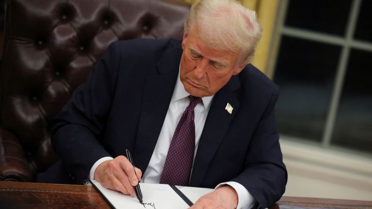 U.S. President Donald Trump signs documents as he issues executive orders and pardons for the January 6 defendants in the Oval Office at the White House on Inauguration Day in Washington, U.S., January 20, 2025. REUTERS/Carlos Barria