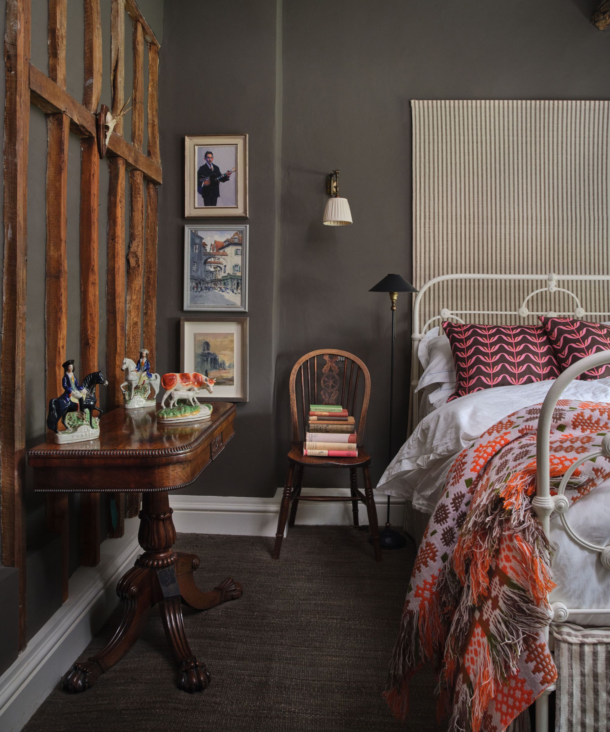 Dark gray painted bedroom with a mahogany side table and a modern bed