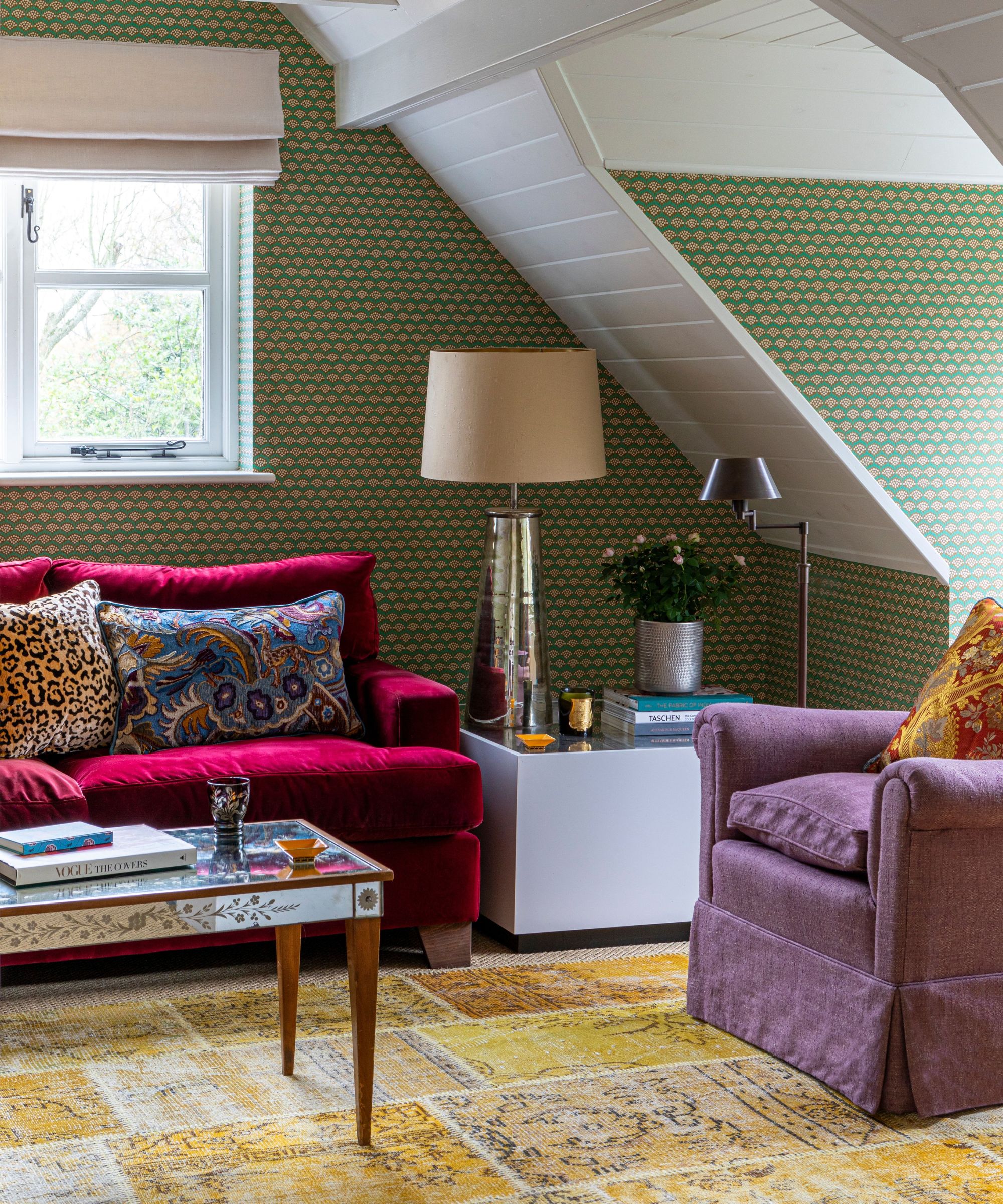 A green living room with colorful sofas and a wood and a mirrored coffee table was sitting on a yellow patch carpet