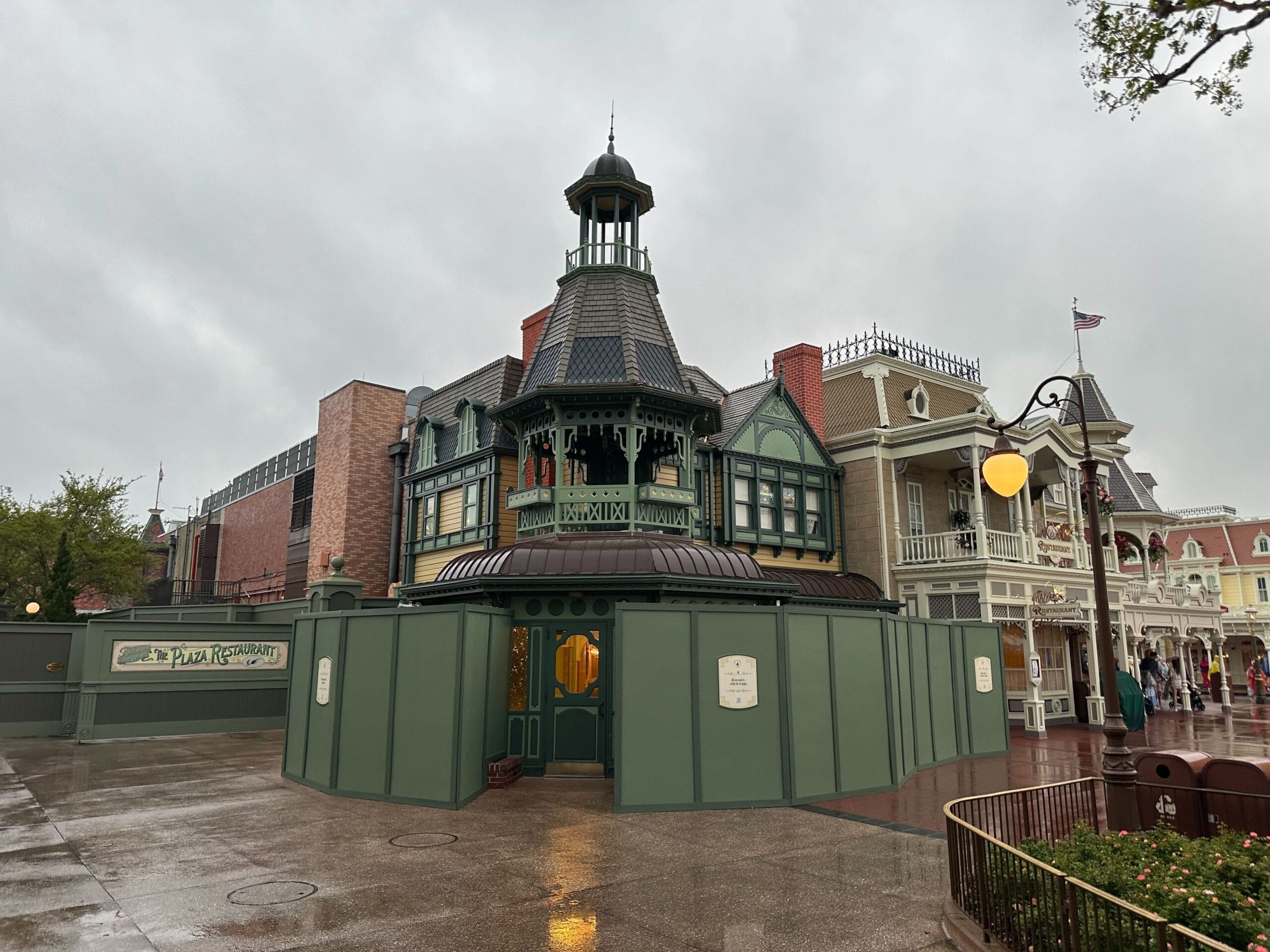 Topic building building under renovation, surrounded by green buildings. Architecture in the Victorian style with a tower on a rainy day.