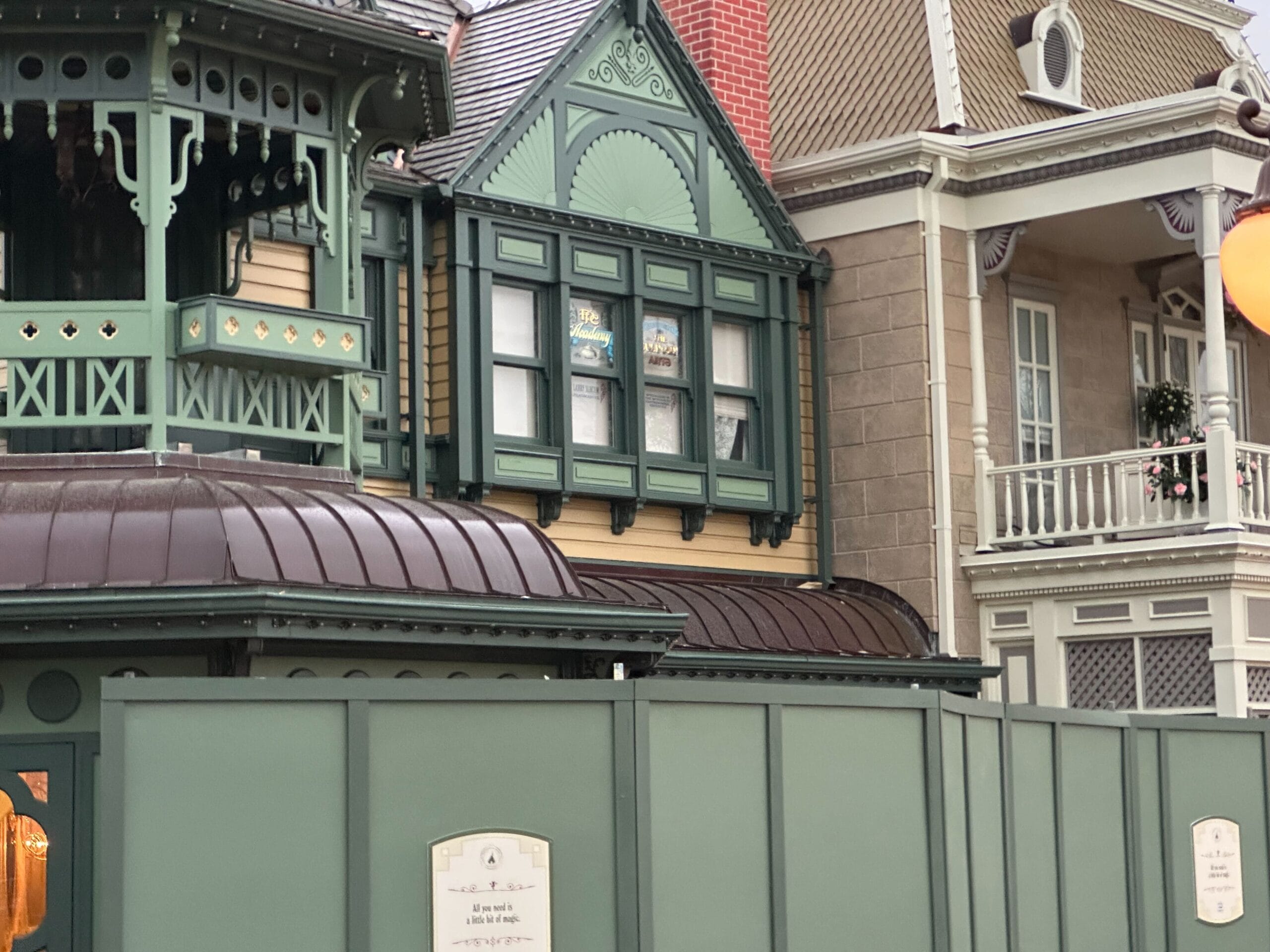 Victorian style building with green details; Construction barriers in the foreground.