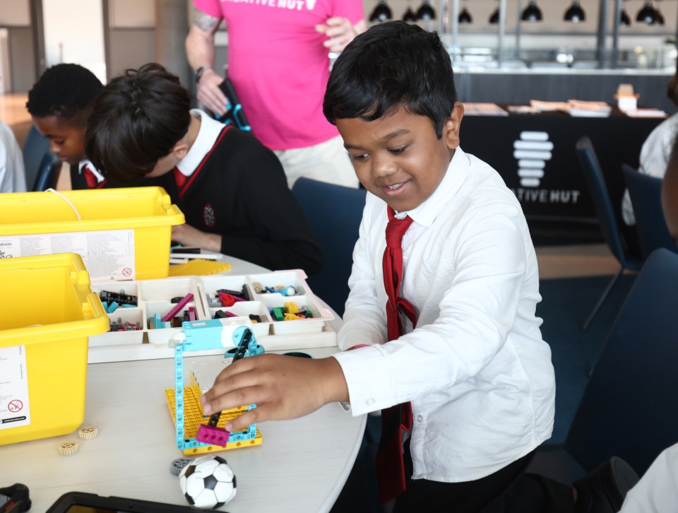 Junge builds a Lego robot.