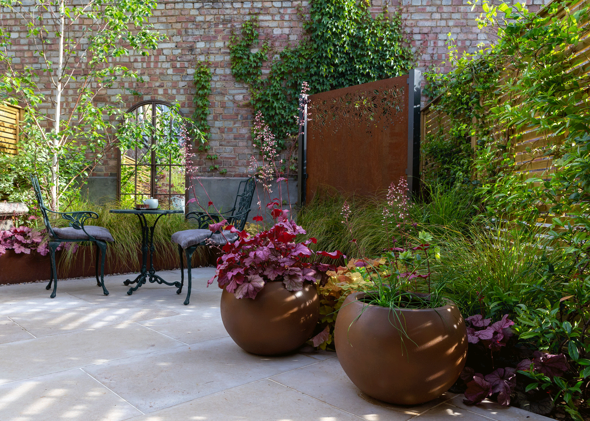 Small terrace with planters, climbing plants, furniture, garden mirrors
