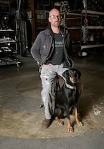 Travis Pond sits with his dog Nola. Teich works from his studio from Oregon City, where he takes scrap pieces and turns them into complicated, shaped works.