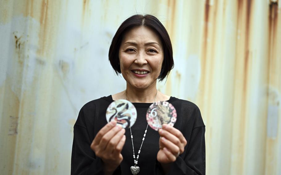 A woman holds car sticker pull pictures with colorful animal designs.