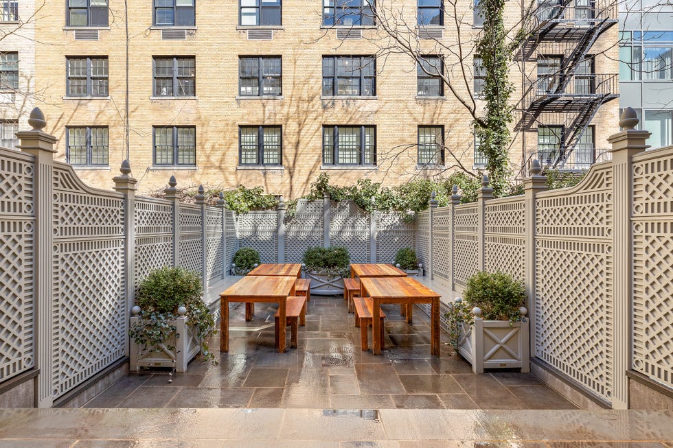 Outdoor courtyard with wooden tables and decorative fences.