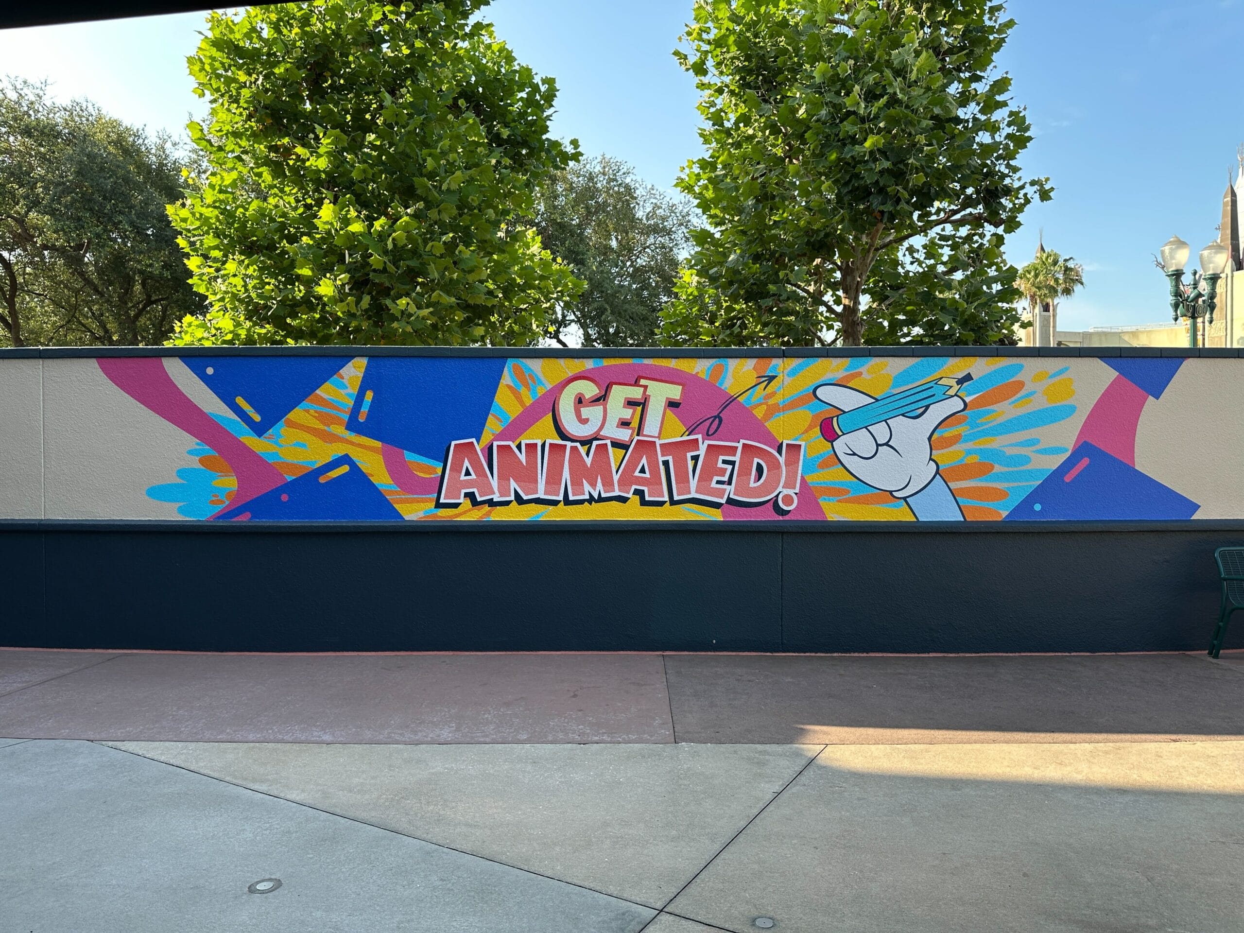Colorful murals with the words "Get animated!" And a cartoon hand with a pencil, surrounded by living designs.