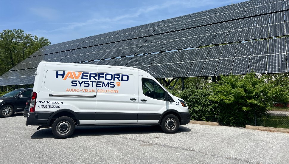 Van parked in front of solar collectors.