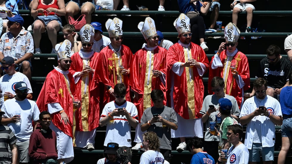 Chicago White Sox fans who are dressed as popes look in front of a ...