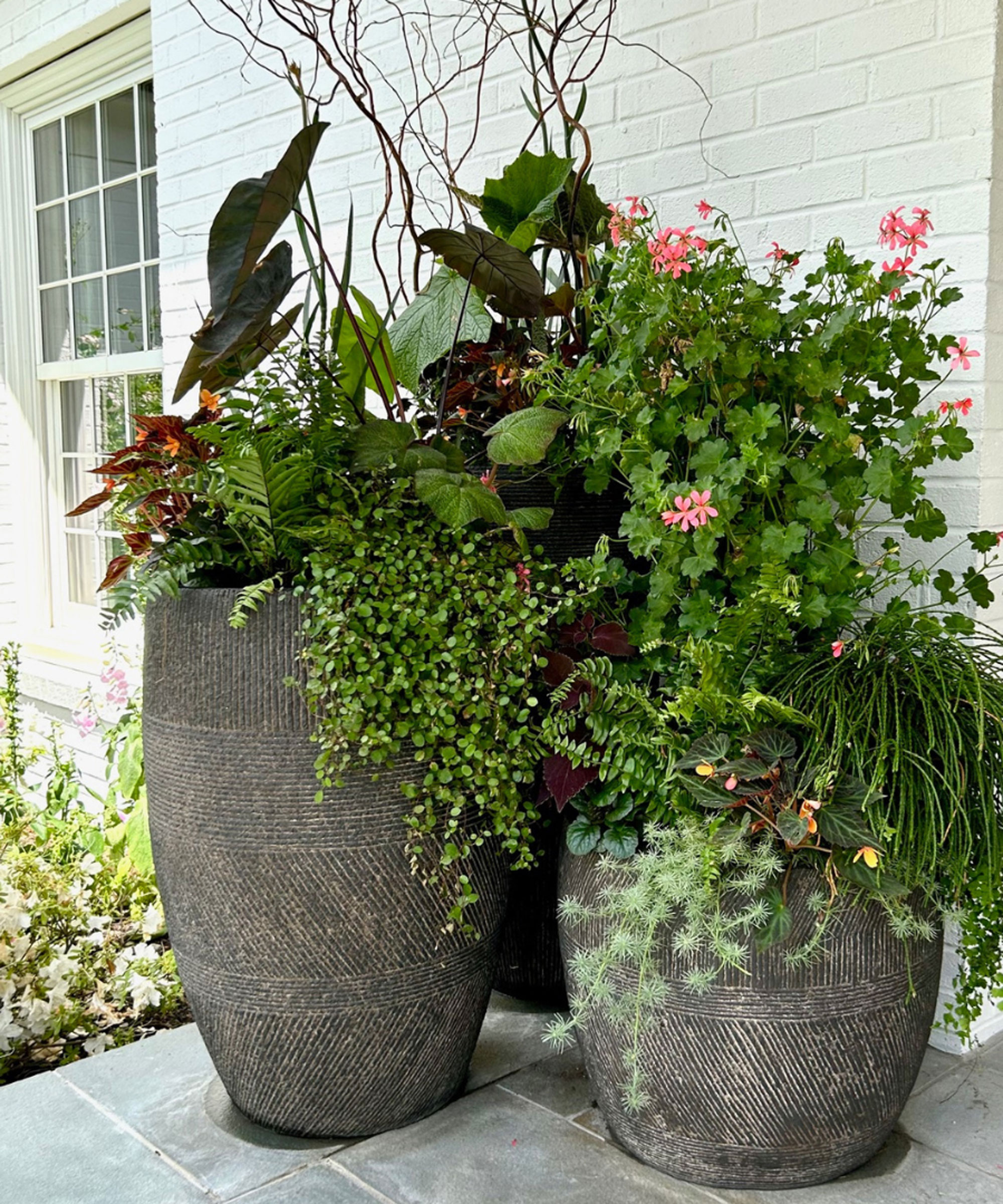 High containers planted with lush green and flowers