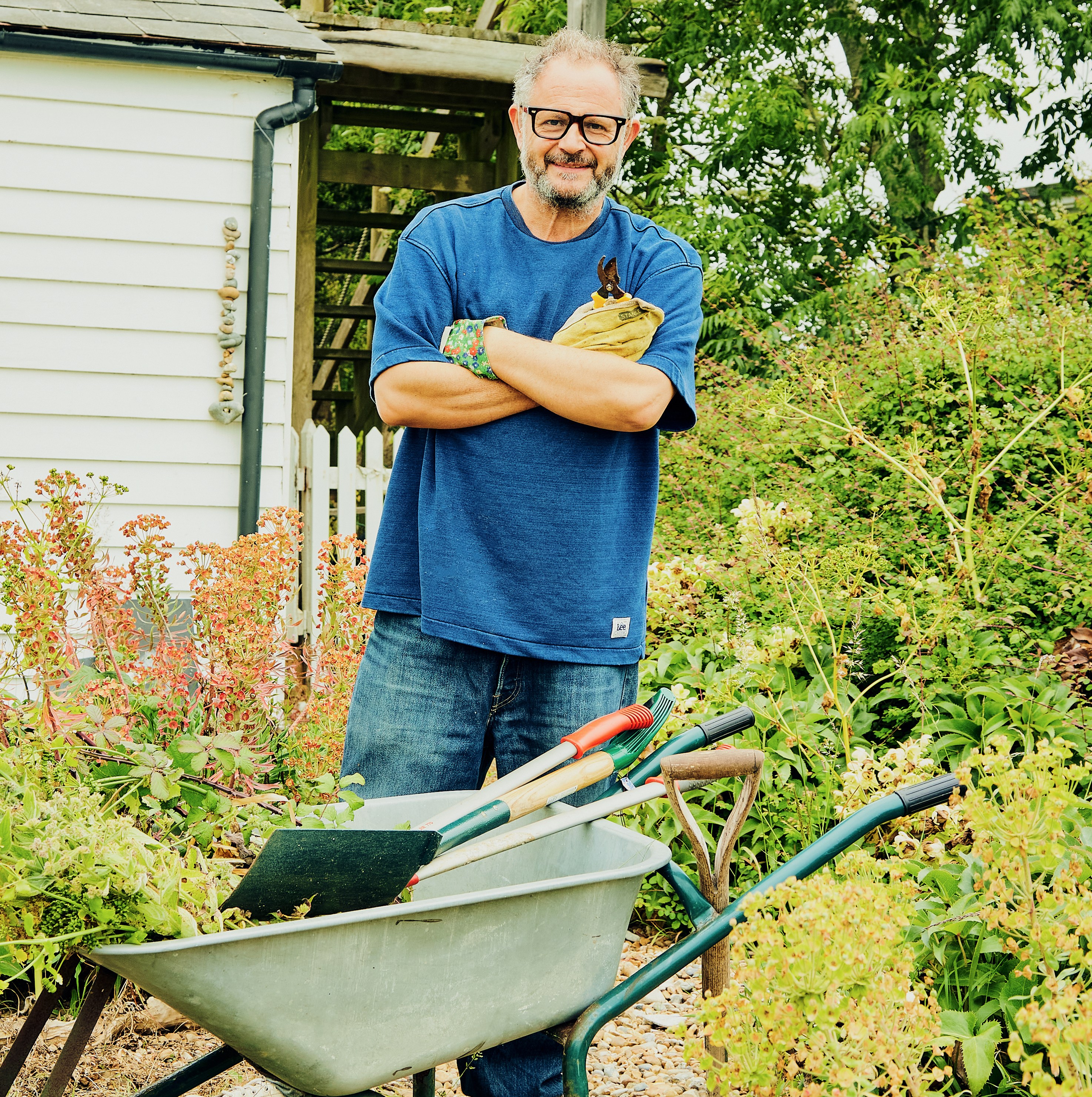 James Brown in his garden with a wheelbarrow.