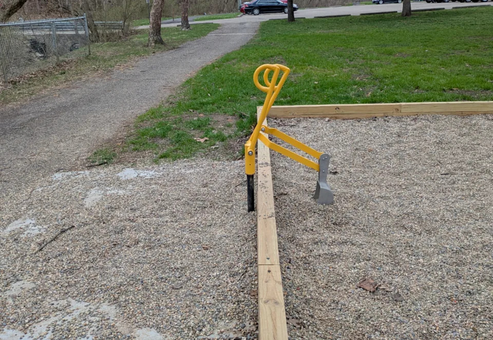 Run on a playground with one end in the gravel and makes it unusable. Grass and a path are in the background
