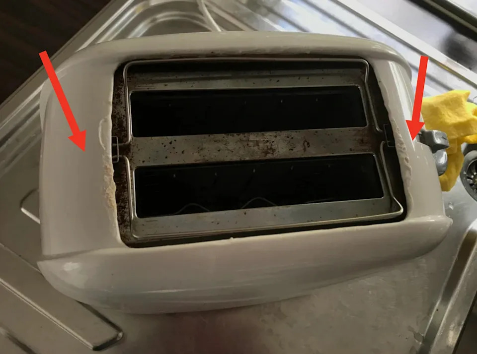 White toaster with two temples that are placed on a metal transmitter surface