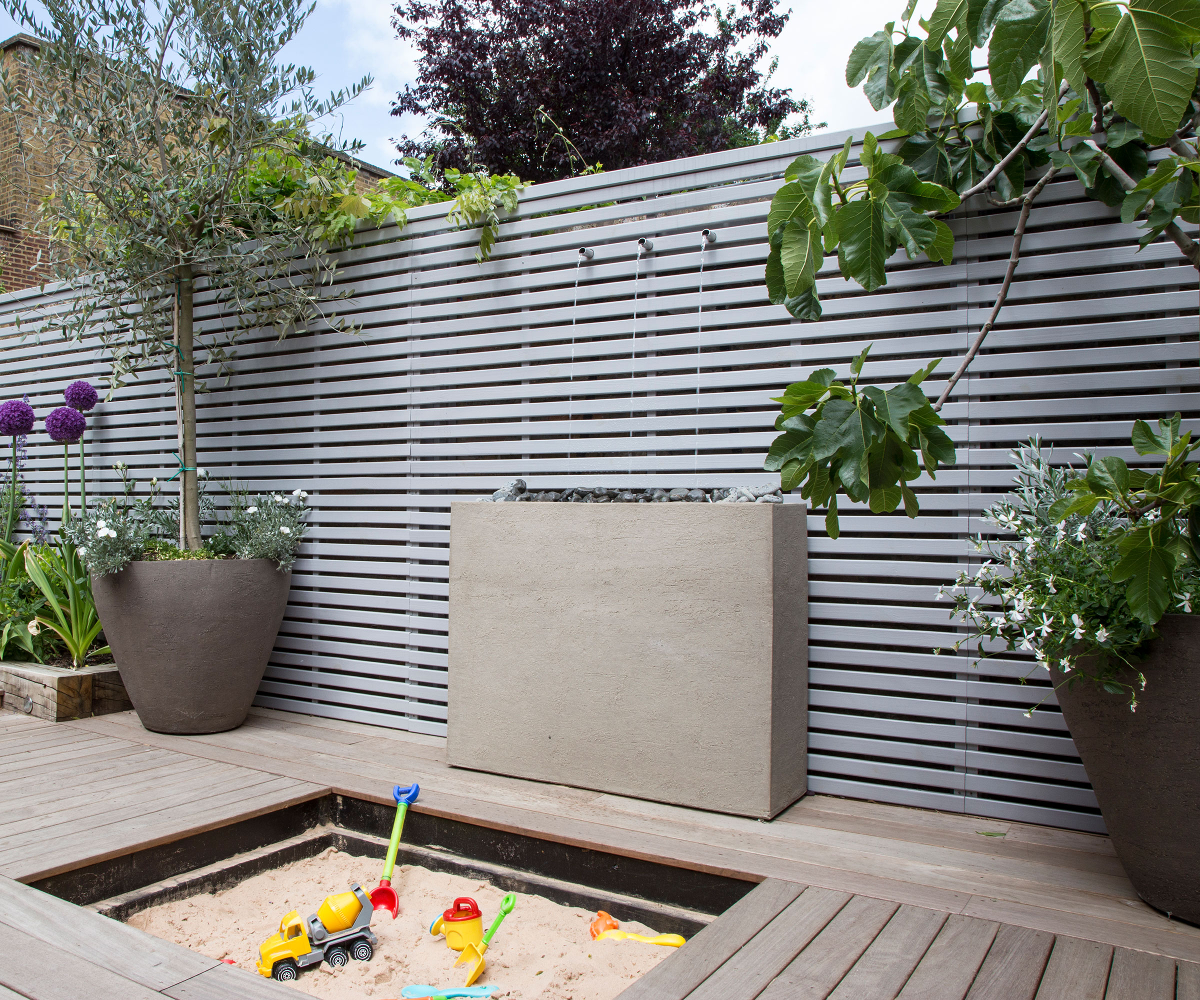 Children's sand box hidden in an increased backyard -deck