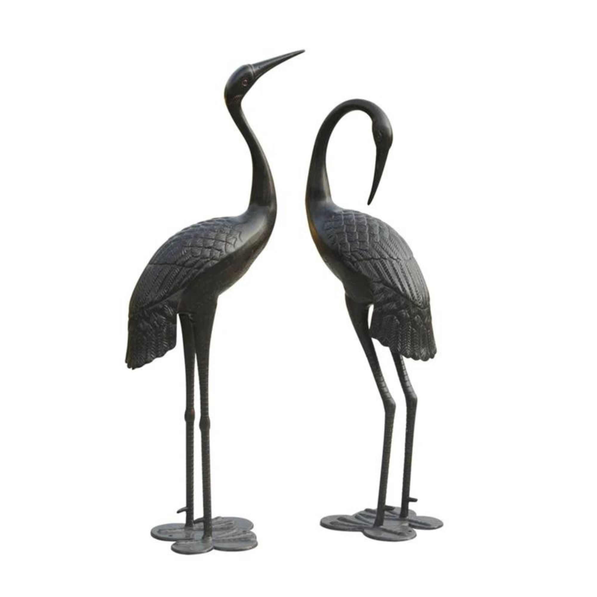 Two metal crane statues on a white background