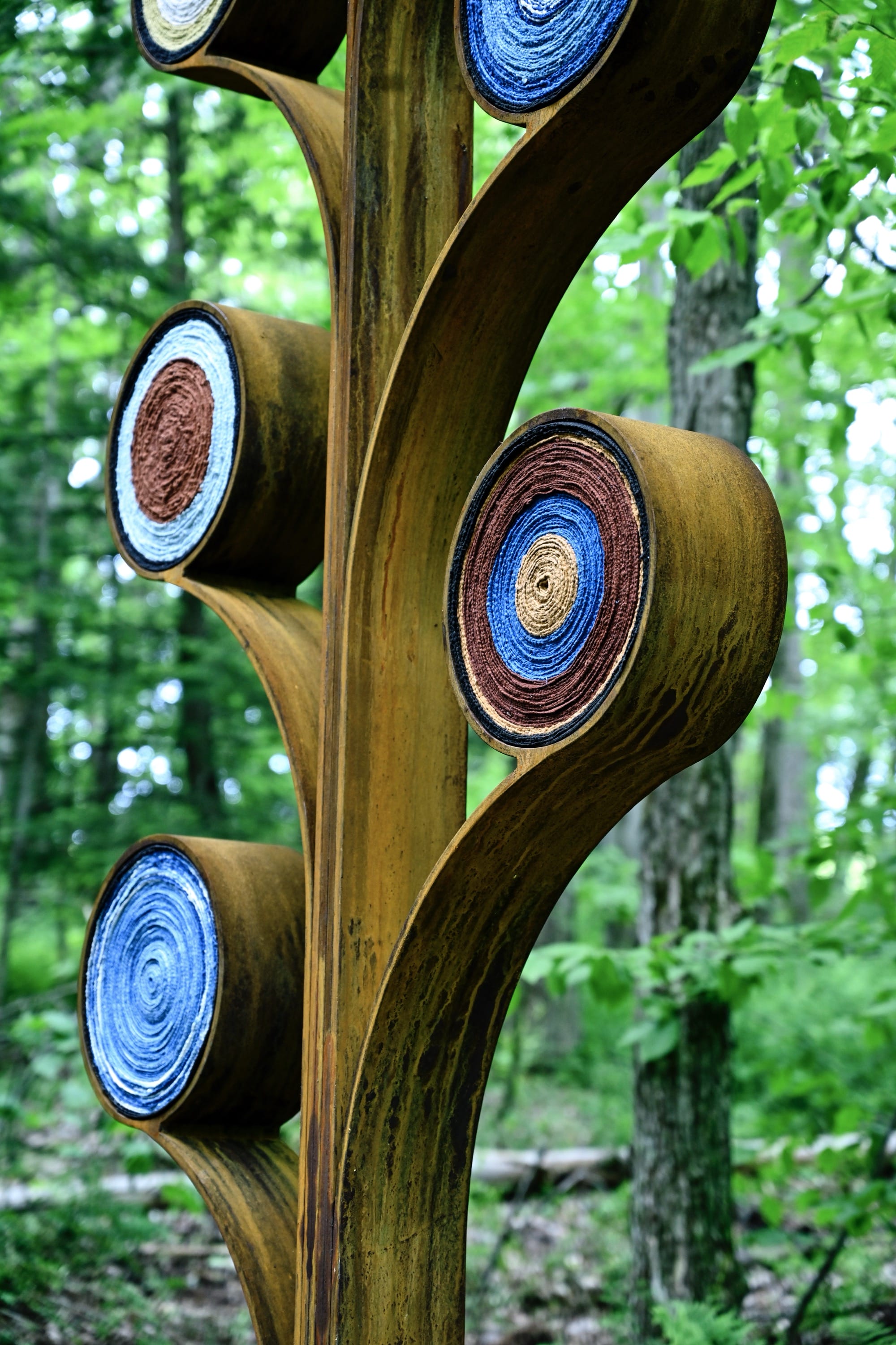 A detail of two abstract tree forms that were installed in a forested area of artists Aboubakar Fofana with colored fiber elements