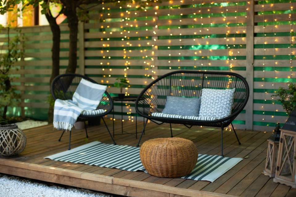 Cozy terrace furniture outdoors with string lights.