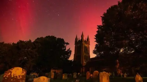 Ian Parkes The northern lights shed light on the sky in red behind Mary's Church in Enville near Stourbridge.