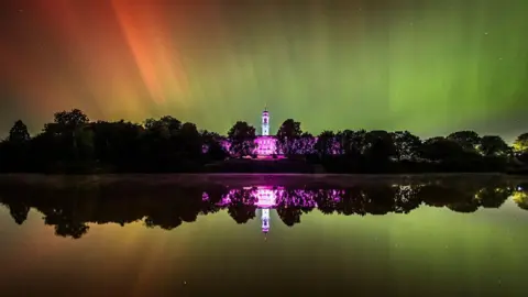Chris Denning The Northern Lights seem in green and red above the Trent building of the University of Nottingham. The picture shows the reflection of the lights in a lake in front of the building.