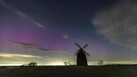 Chris Denning The Aurora can be seen in green and purple about Tysoe Windmühle in the Cotswolds.