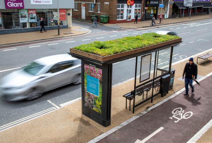 A bus stop is crowned with green plants 