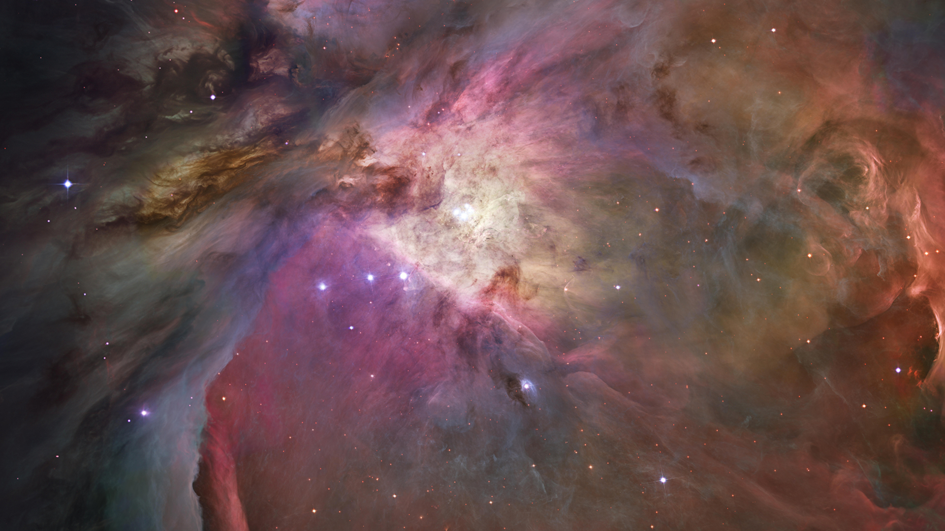 A swirling fog scene is shown with multicolored interstellar clouds, which are illuminated with the light of nearby stars, many of which are visible.