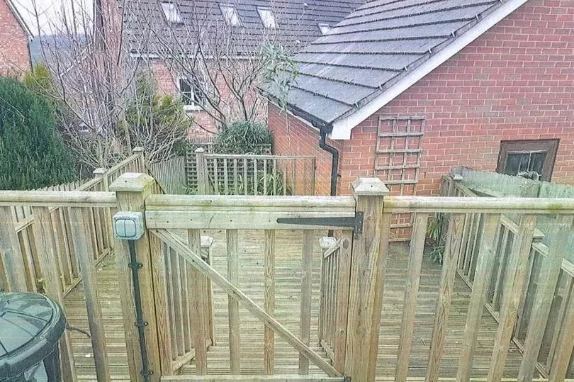 The big and yet inconspicuous garden deck in the background of the woman of the house