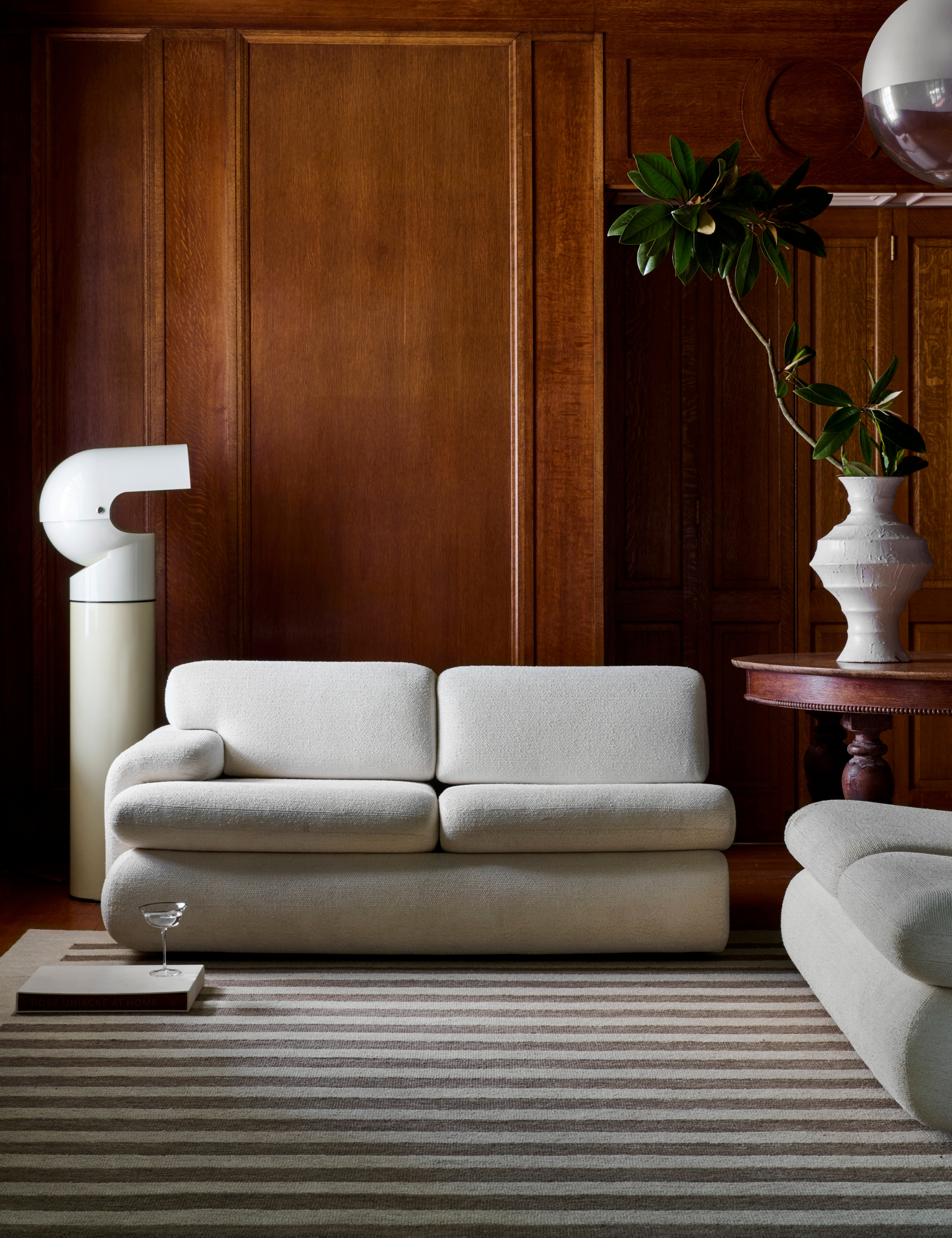 Striped carpet in a wood-panelled living room with modern cream furniture