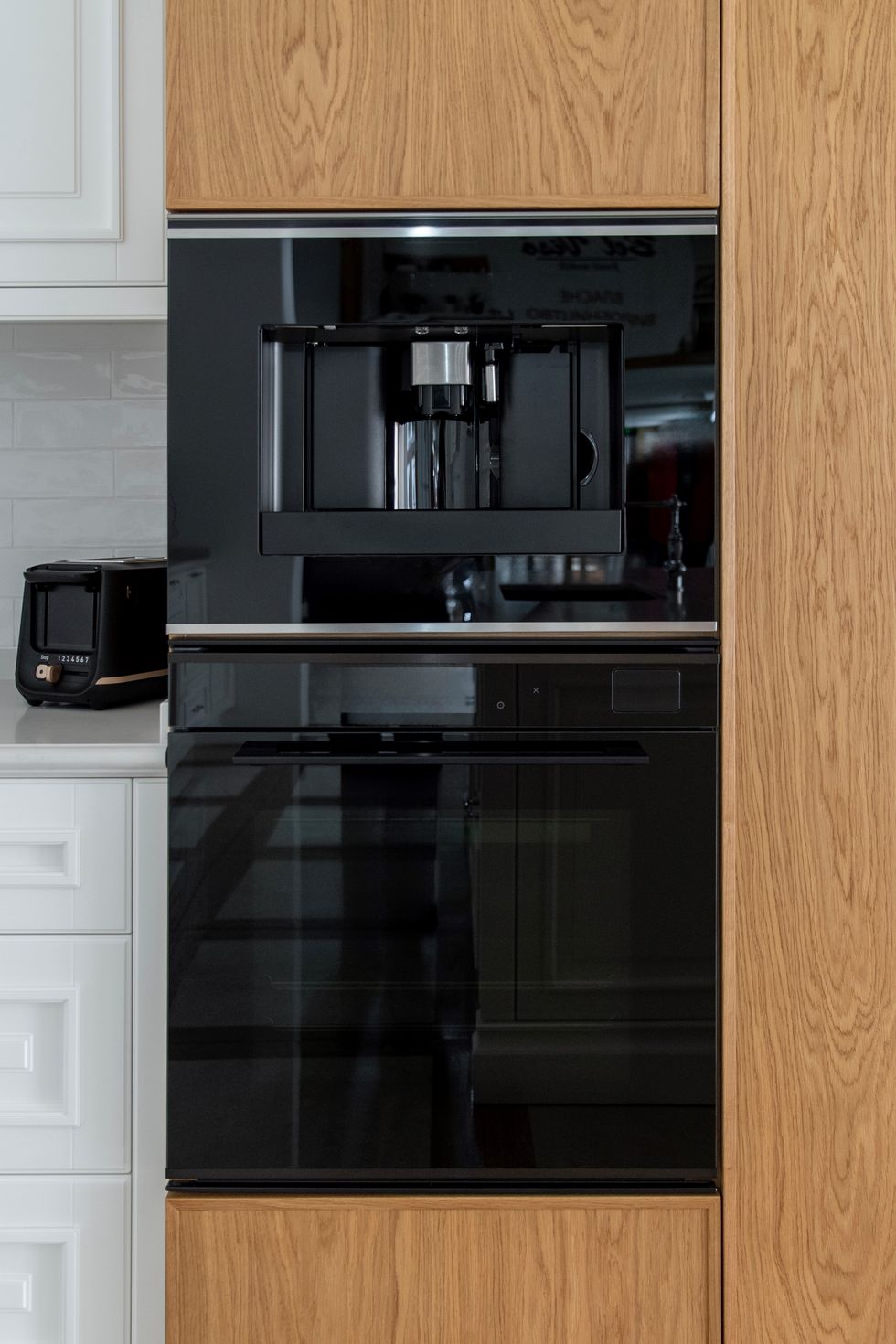 Built-in coffee maker and oven in an oak kitchen