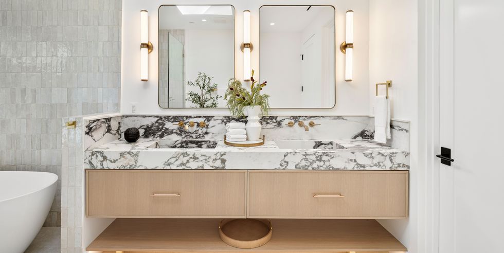 modern bathroom with marble countertop and double mirrors.