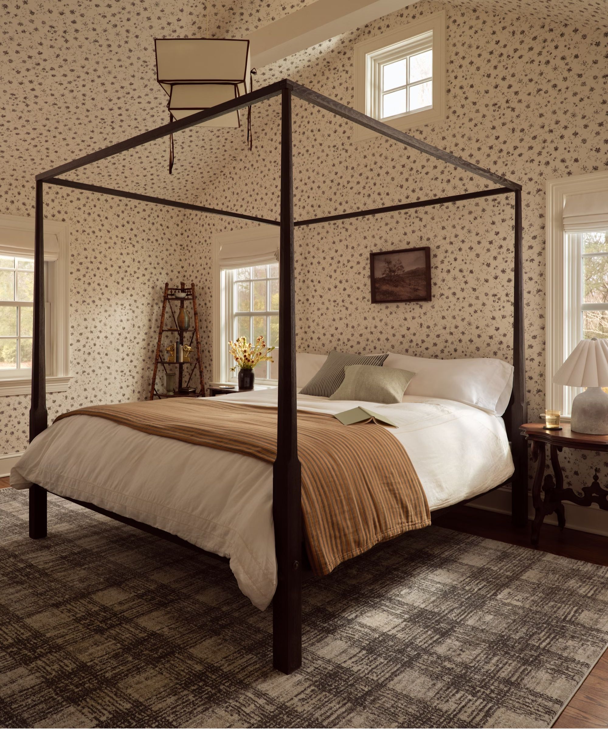 Bedroom with a black four-poster bed, floral walls and ceiling, a neutral and beige bed and a checkered gray-brown rug underneath