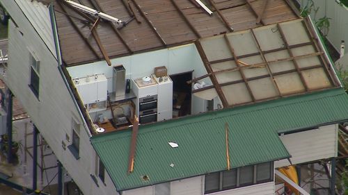 Storms in southeast Queensland are ripping off roofs, dropping huge hail and leaving 95,000 people without power