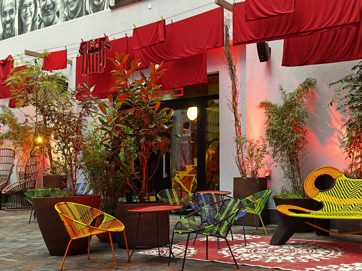 Red linen and colorful furniture on the hotel terrace 25hours Hotel The Trip